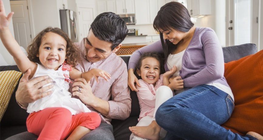 A mom and Dad are enjoying some play time with two little children.