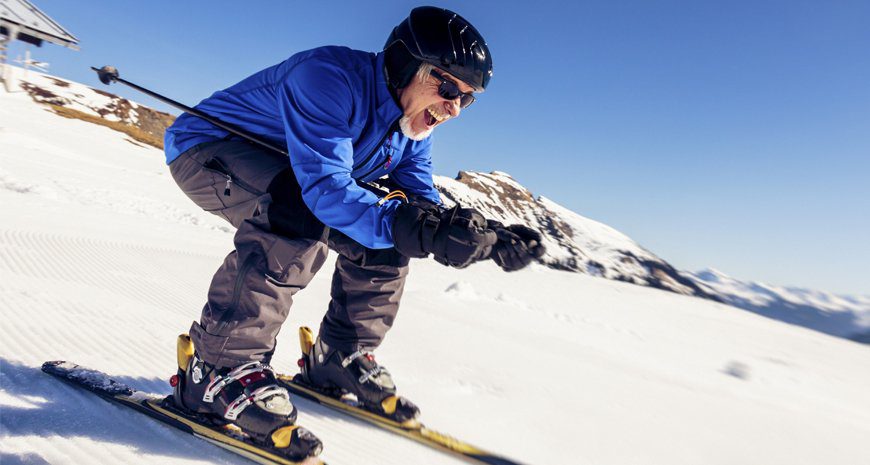 A man skiing down a hill for exercise.