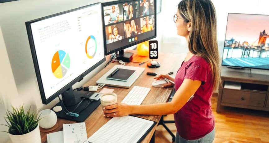 Woman employee working remote at home with standing computer desk