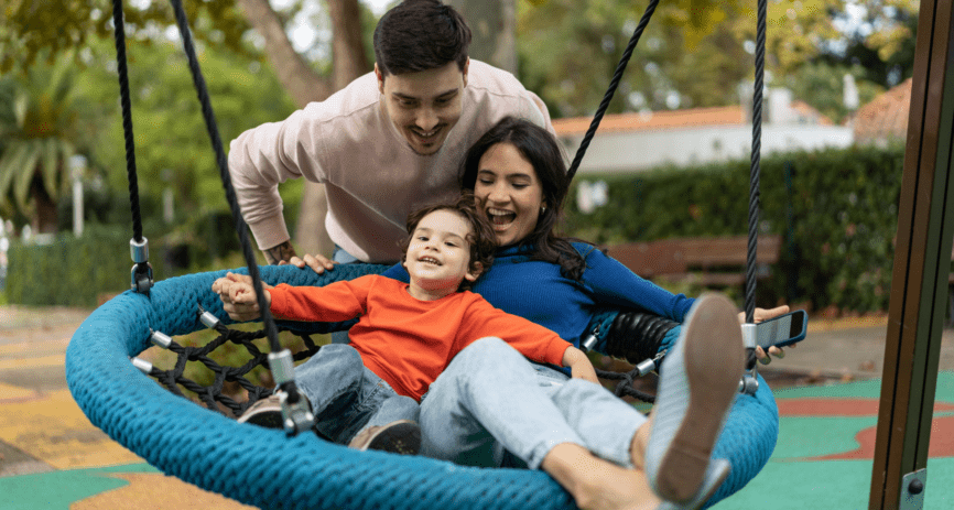 Family playing on the swing at the park