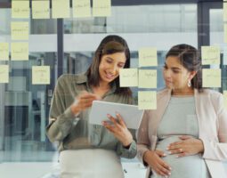 Pregnant employee working with a colleague.