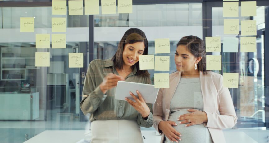 Pregnant employee working with a colleague.