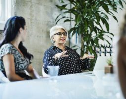 Female business owner leading team discussion during project meeting in conference room.