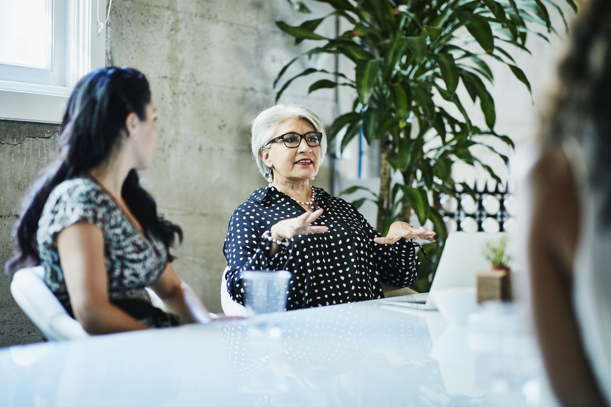 Female business owner leading team discussion during project meeting in conference room.