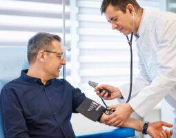 Doctor checking blood pressure of a mature male patient.