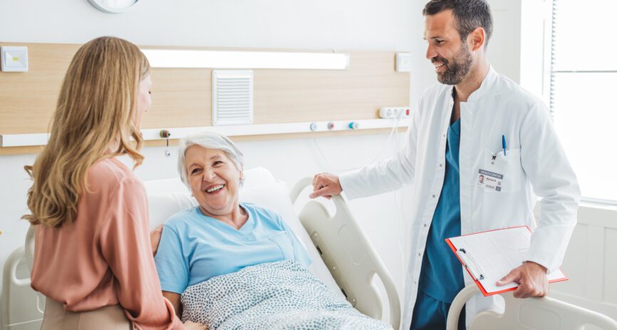 A woman visits her elderly mother at the hospital. They're talking to the doctor.