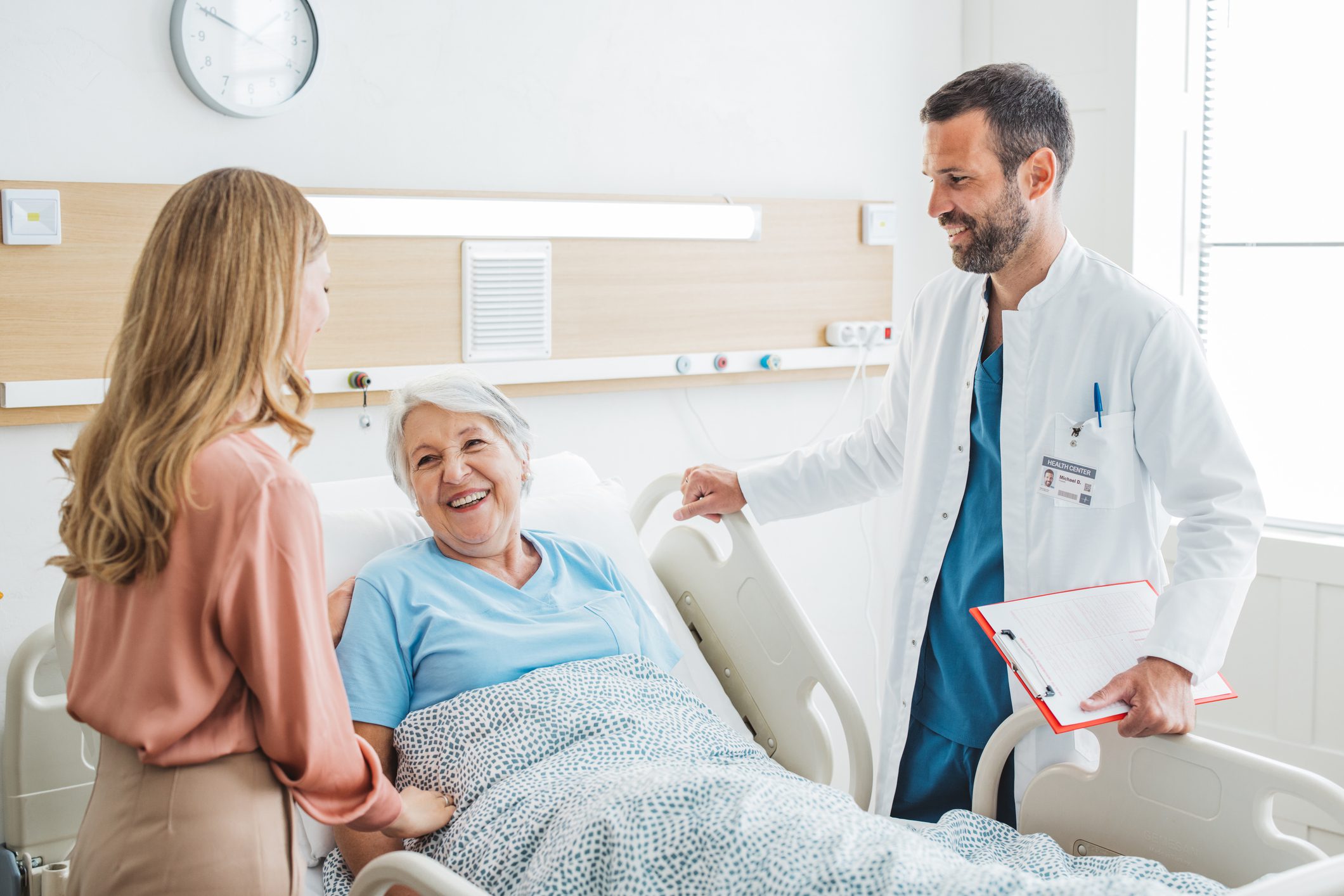 A woman visits her elderly mother at the hospital. They're talking to the doctor.
